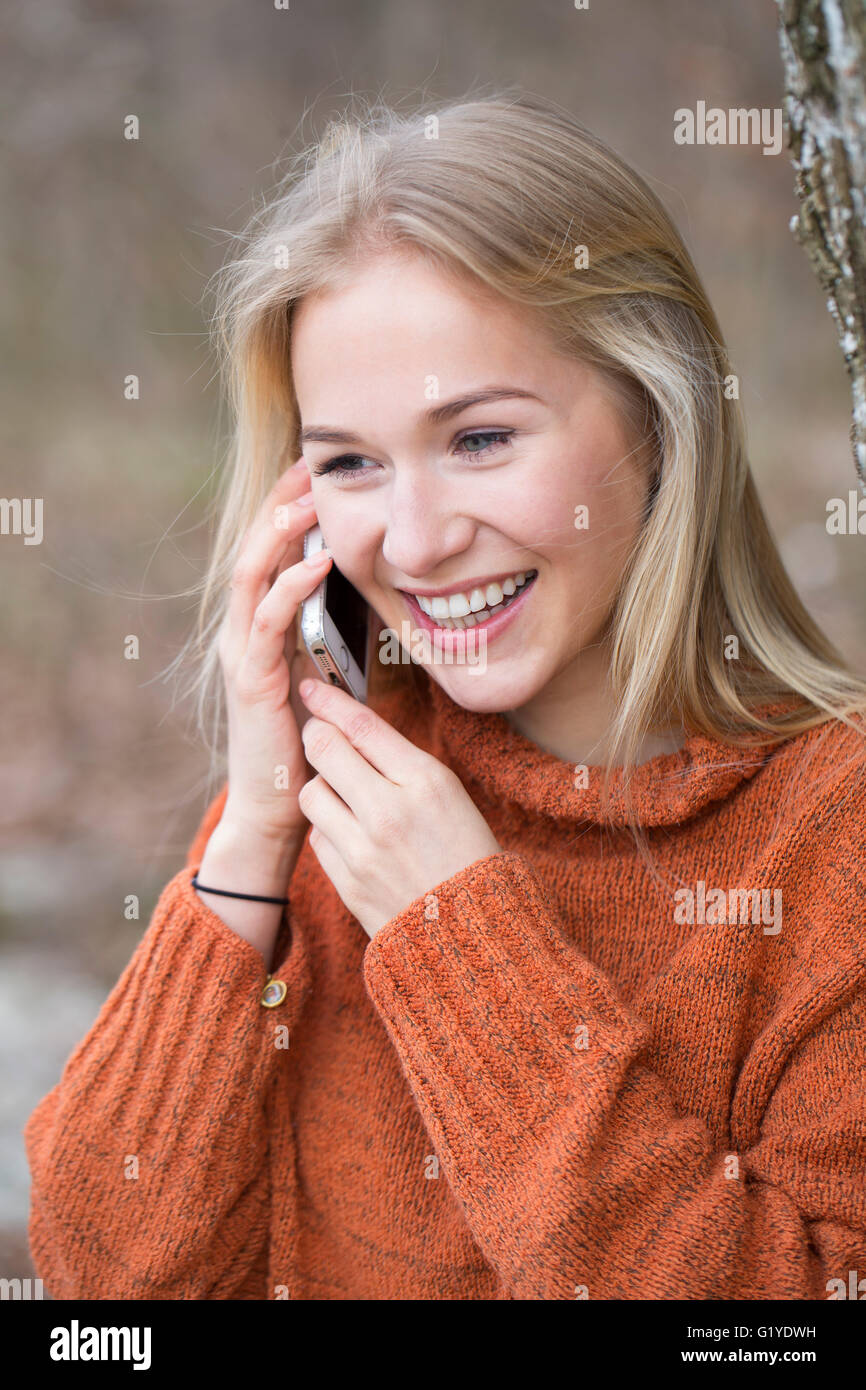 Blond young woman phoning with a mobile Stock Photo