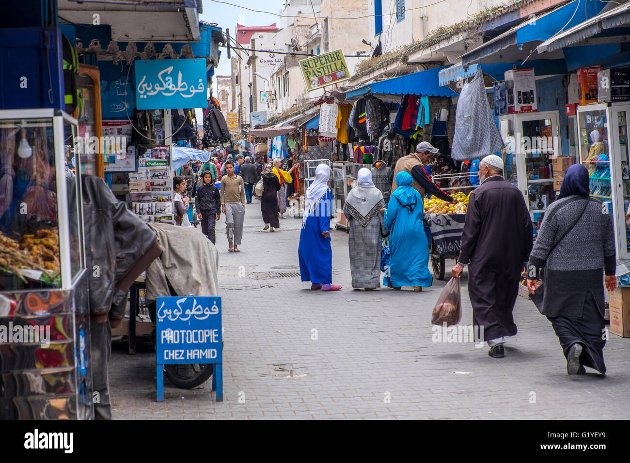 Moroccans going about their daily business Inside the bustling medina (old town) of Essaouira, Morocco Stock Photo