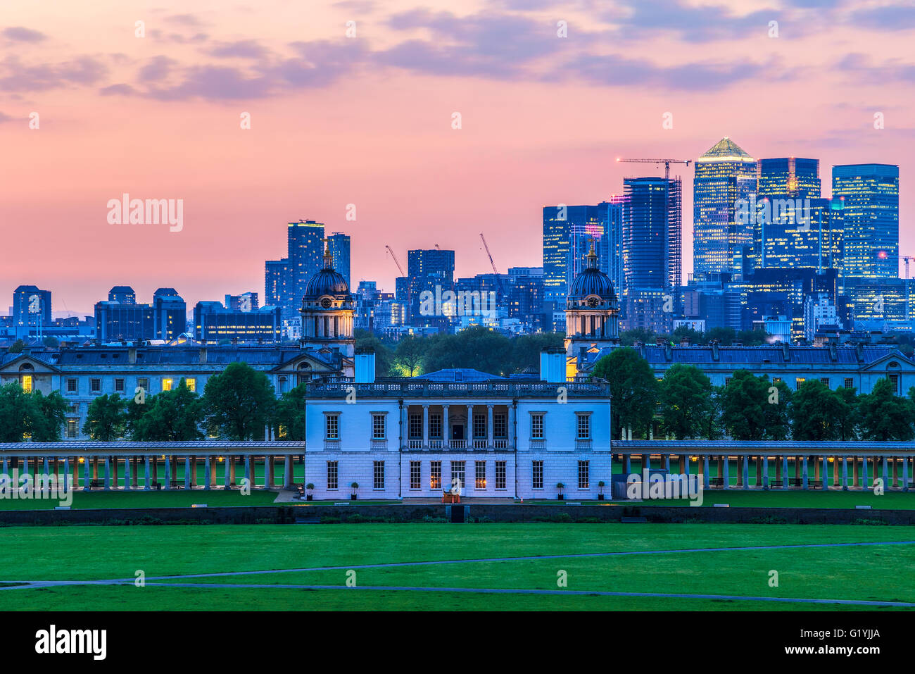 View of Queens House and Canary Wharf from Greenwich Park, London with a sunset sky Stock Photo