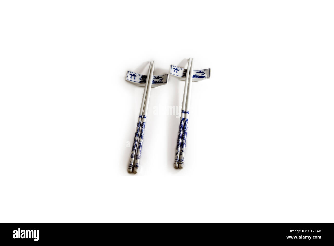 Lay flat image of two pairs of blue and white porcelain chopsticks on rests Stock Photo