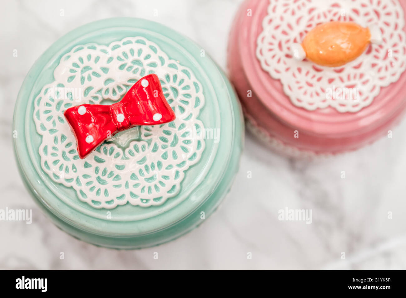 Colorful Ceramic Round Jars With Lace Patterns On White Marble