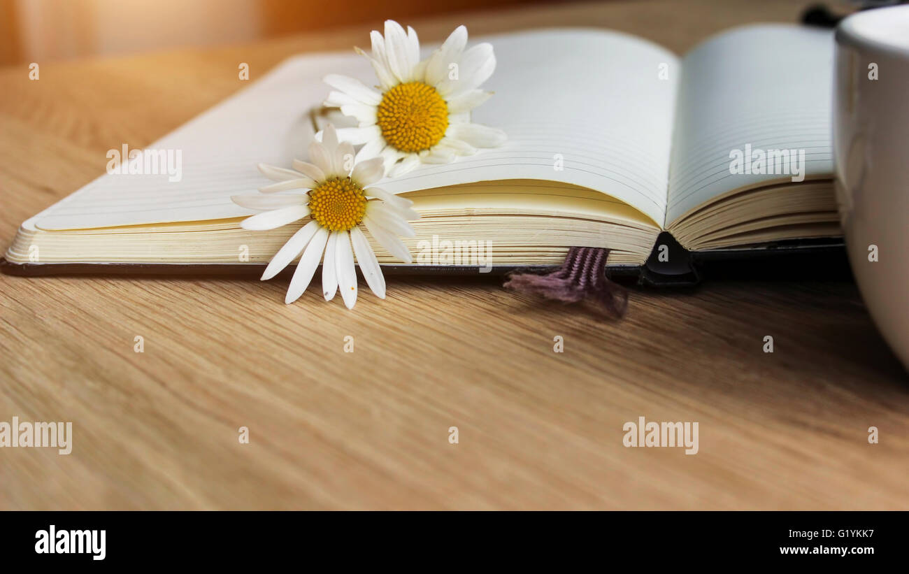 Flyleaf disclosed notebook, flowers, coffee - close up Stock Photo - Alamy