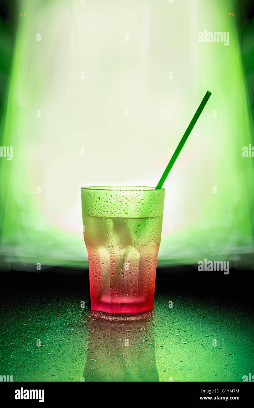 wet pink glass with green straw Stock Photo