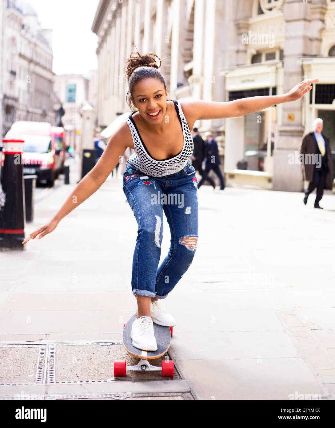 young woman skate boarding in the street Stock Photo