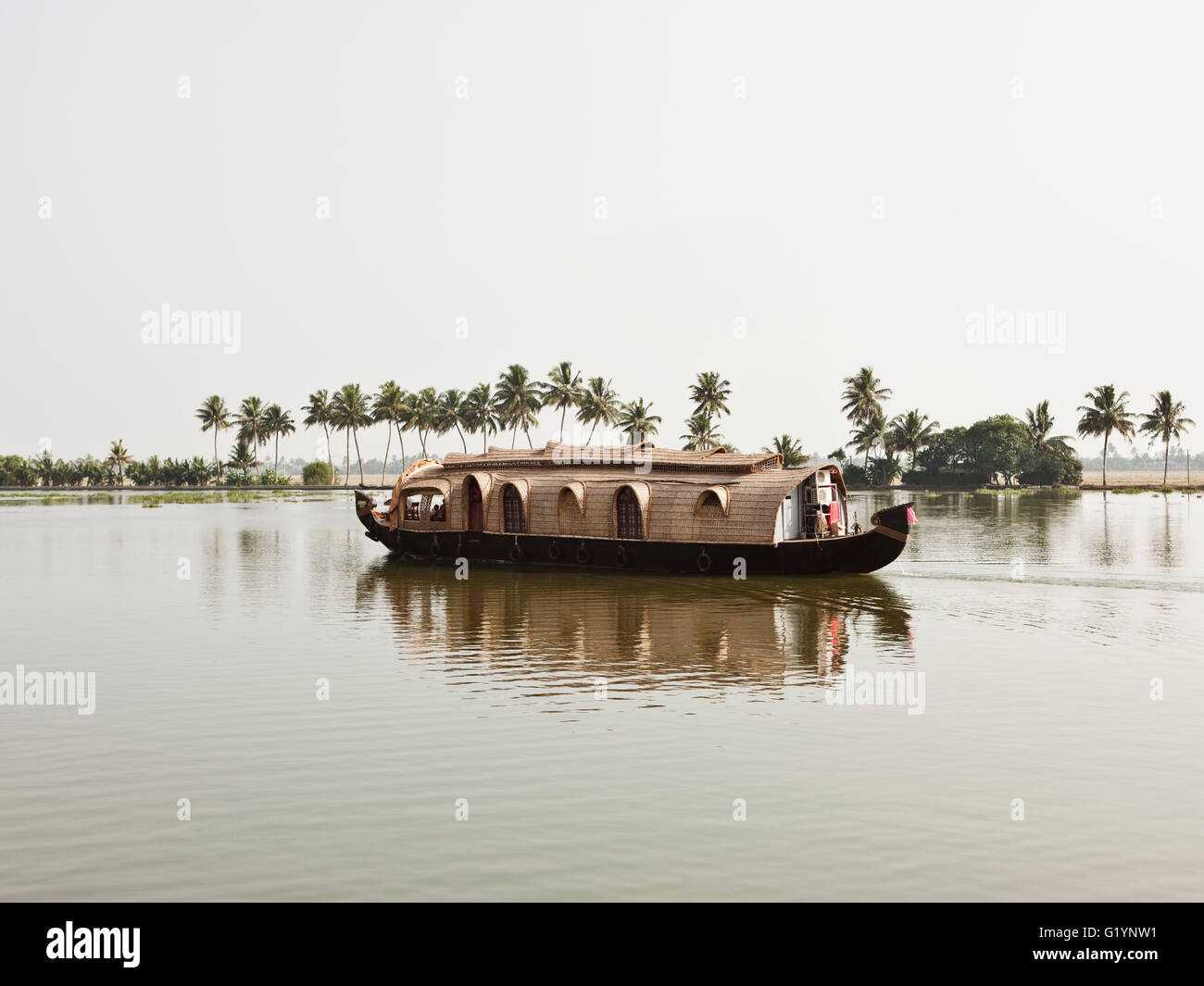 Houseboats along a channel in the Kerala backwaters.India Stock Photo