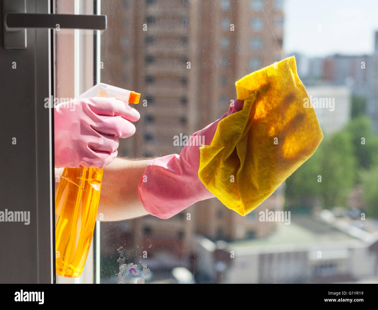 washing home window - washer washes window glass with detergent in apartment house Stock Photo