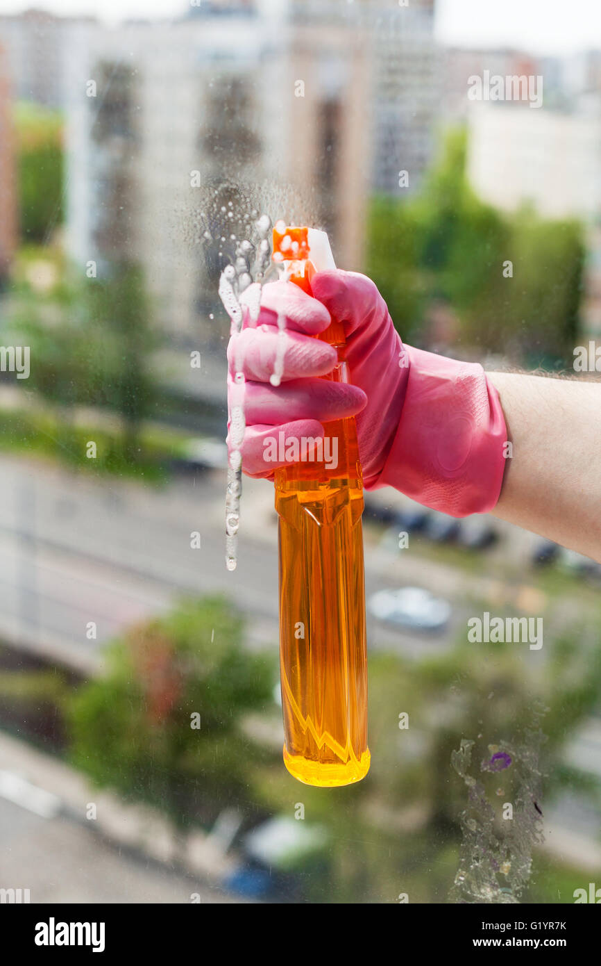 Window Spray Liquid washing home window - hand sprays liquid from spray bottle to window ...