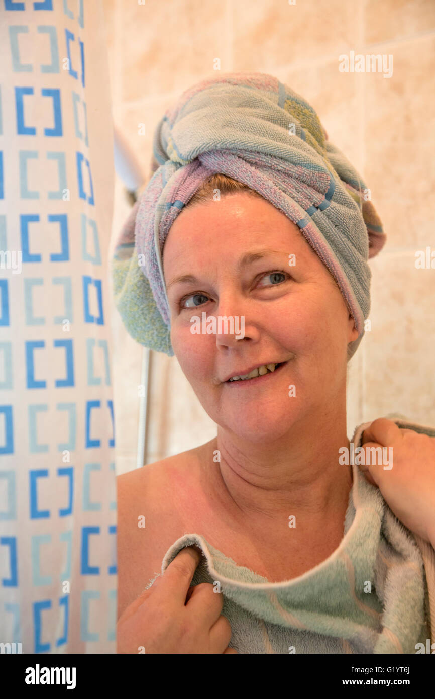 50 year old woman in shower with towel on head. Stock Photo