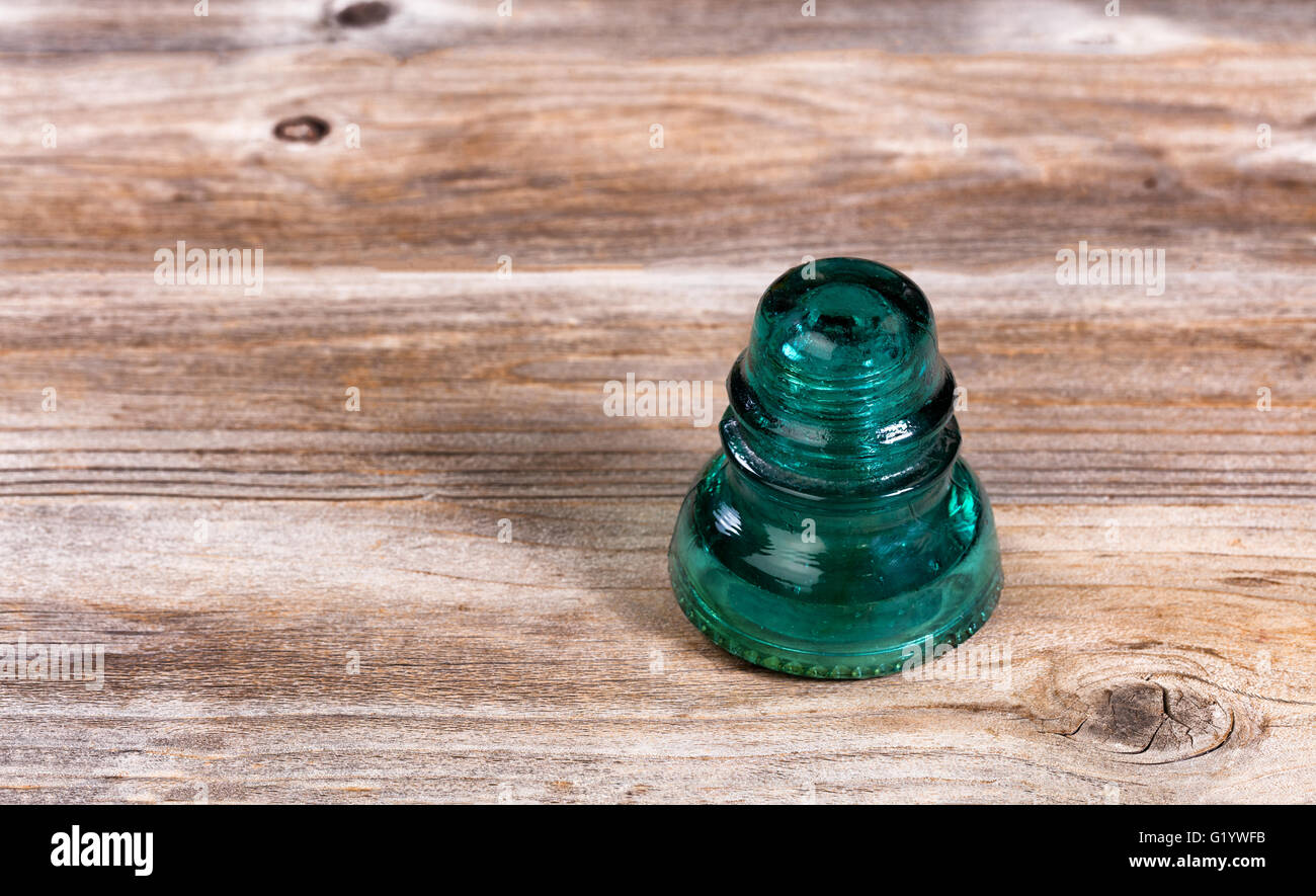 Antique electric glass insulator on rustic wood. Stock Photo