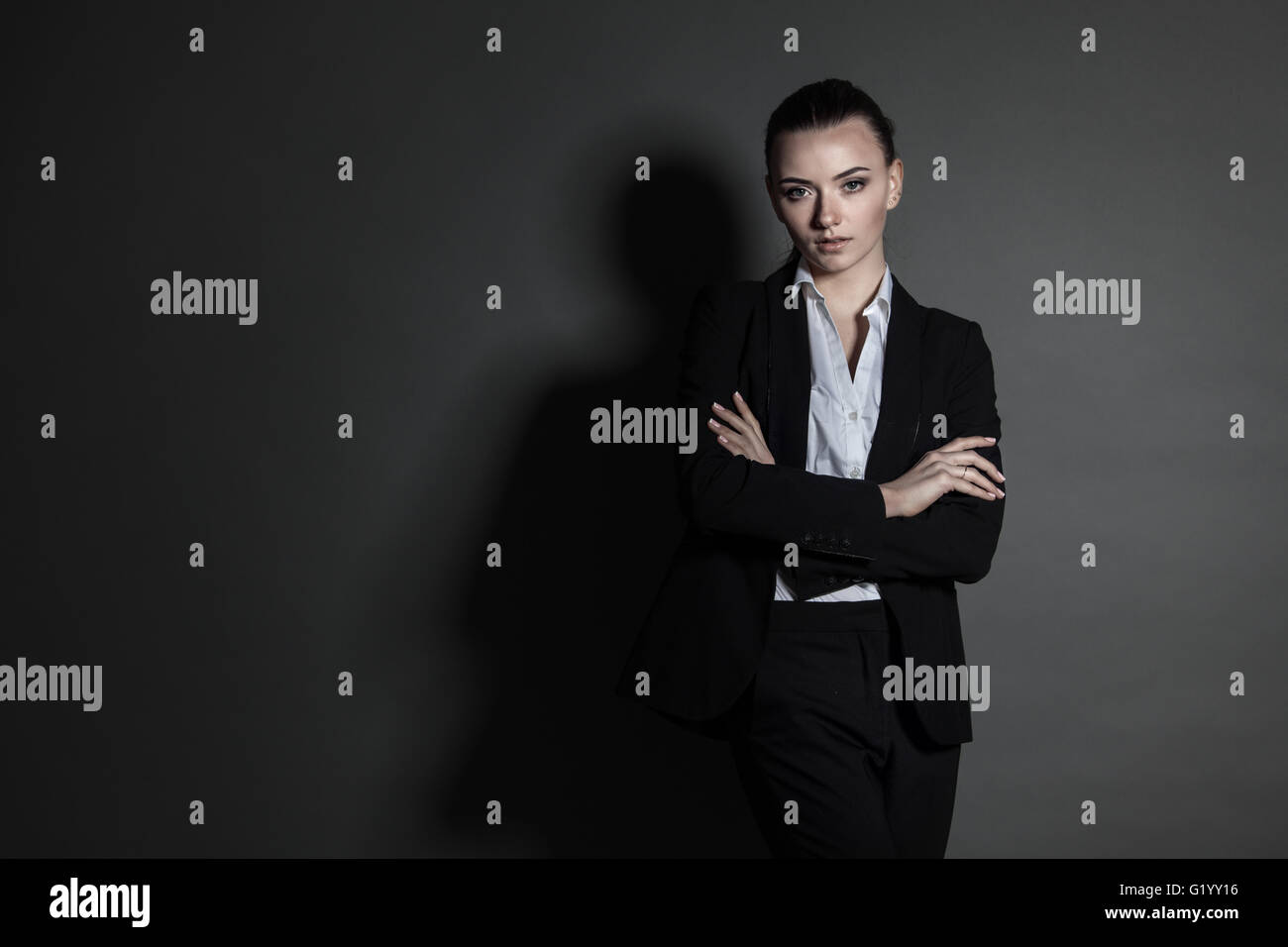 Portrait of young businesswoman in black suit on dark background Stock ...