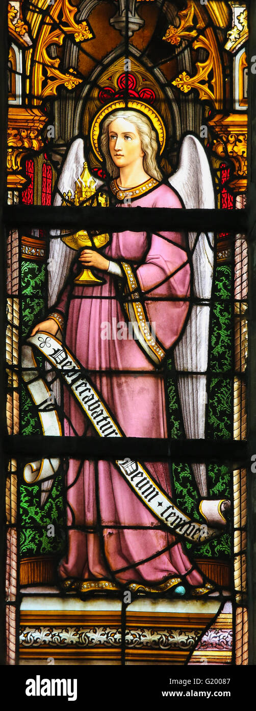 LIER, BELGIUM - MAY 16, 2015: Stained Glass window in St Gummarus Church in Lier, Belgium, depicting and Angel holding a monstra Stock Photo