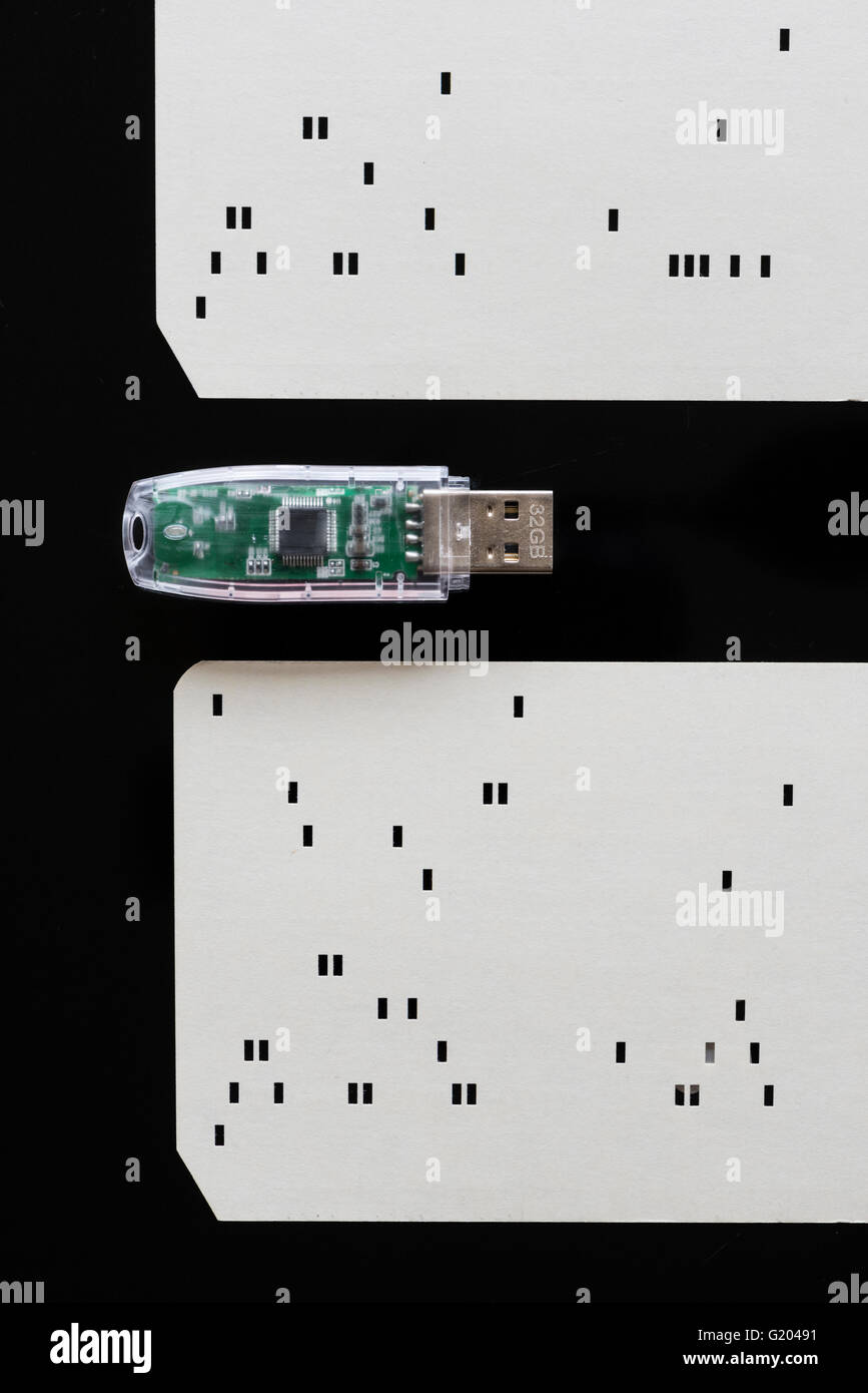 Close-up of a modern 32GB USB memory stick from 2016 next to historic early computer punch card (from circa 1970) Stock Photo