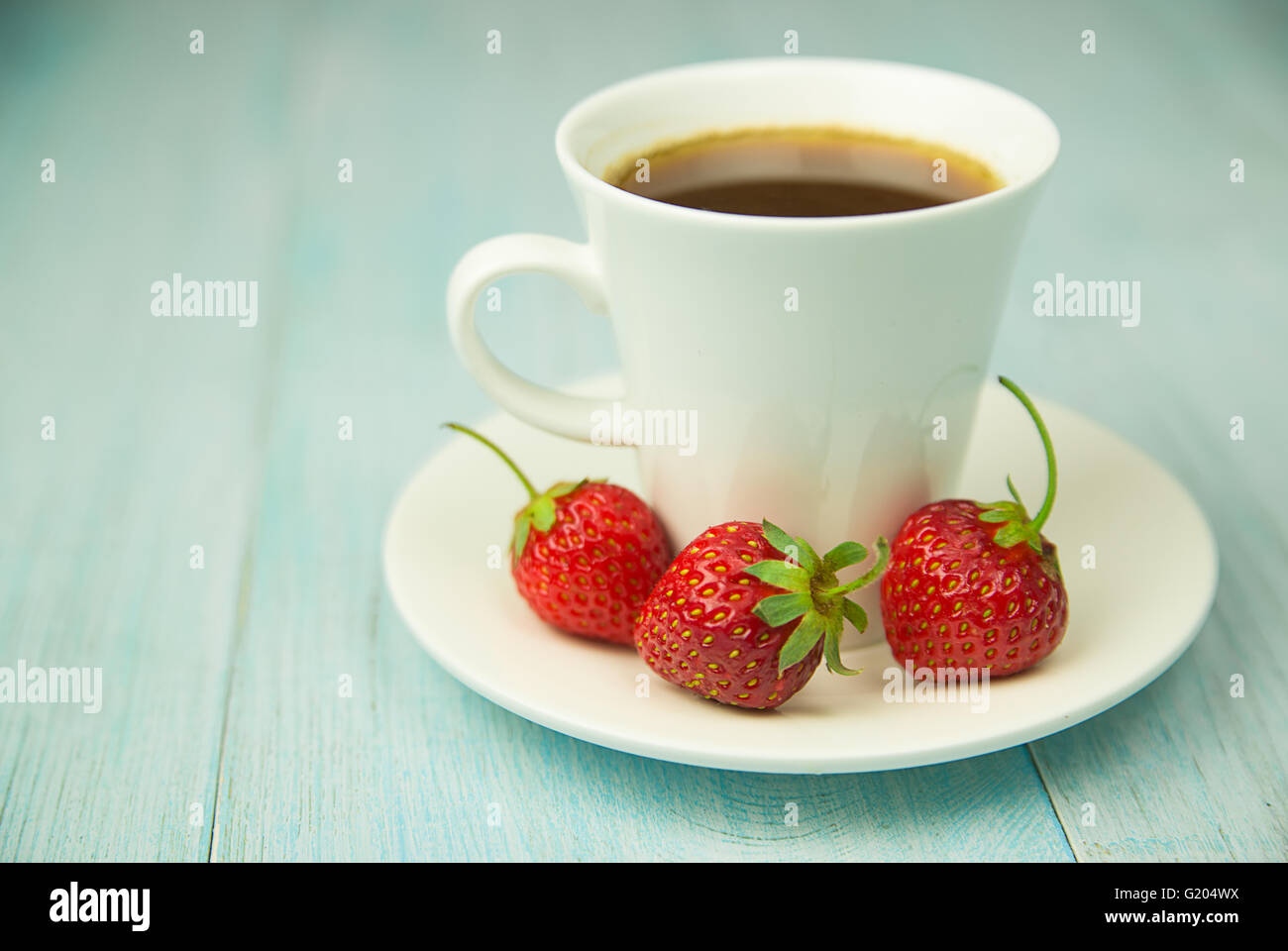 Cup and strawberry on over blue Stock Photo
