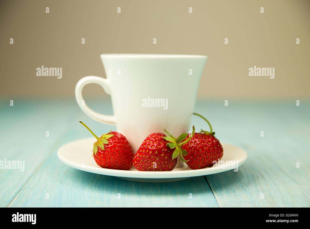 Cup and strawberry on over blue Stock Photo