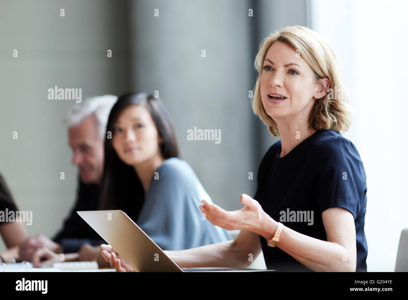 Businesswoman gesturing and talking in meeting Stock Photo