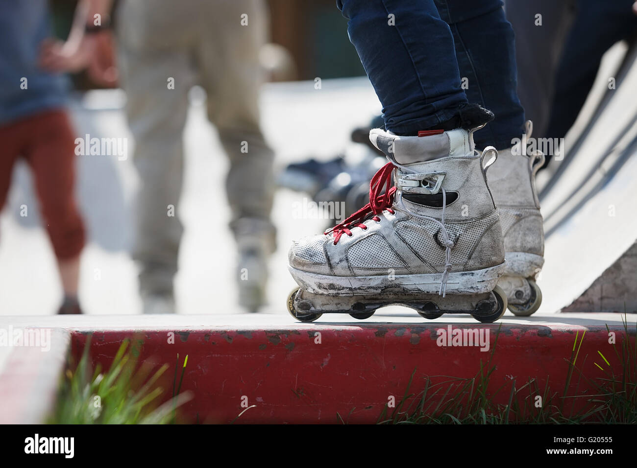 Feet of rollerblader wearing aggressive inline skates standing on top