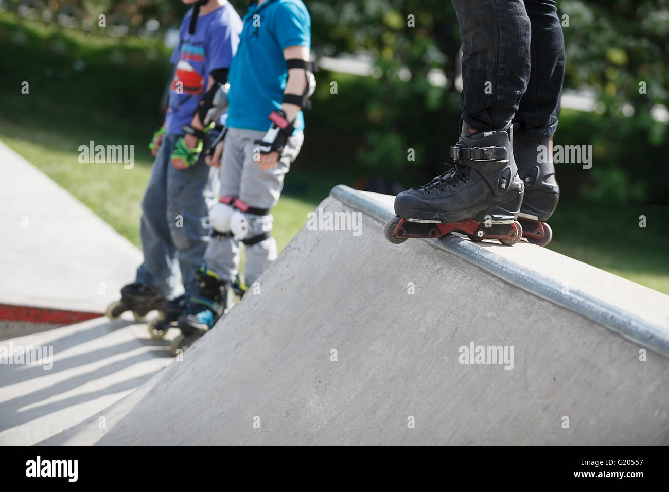 Feet of rollerblader wearing aggressive inline skates standing on top