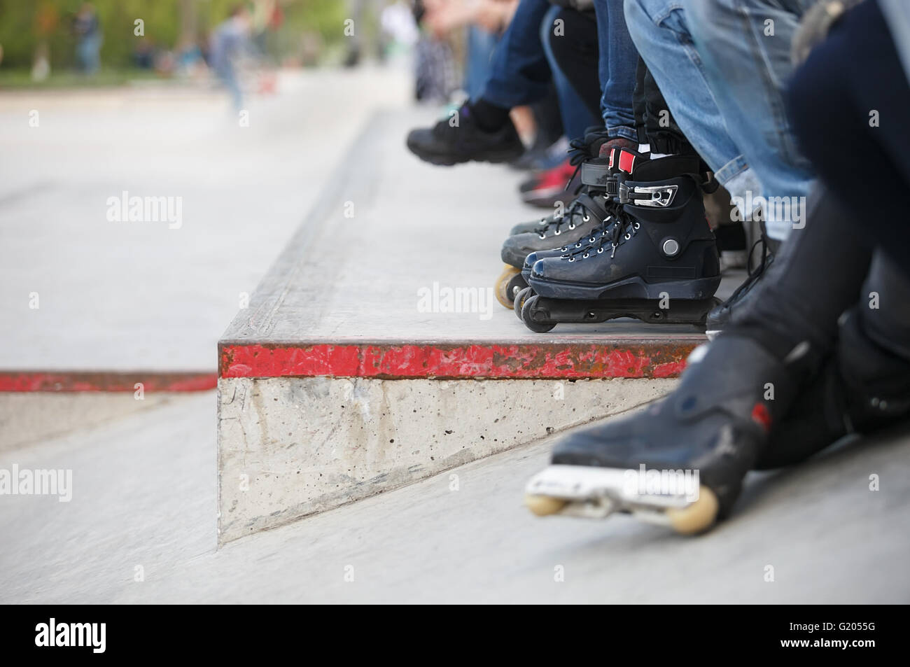 Feet of rollerblader wearing aggressive inline skates sitting on a