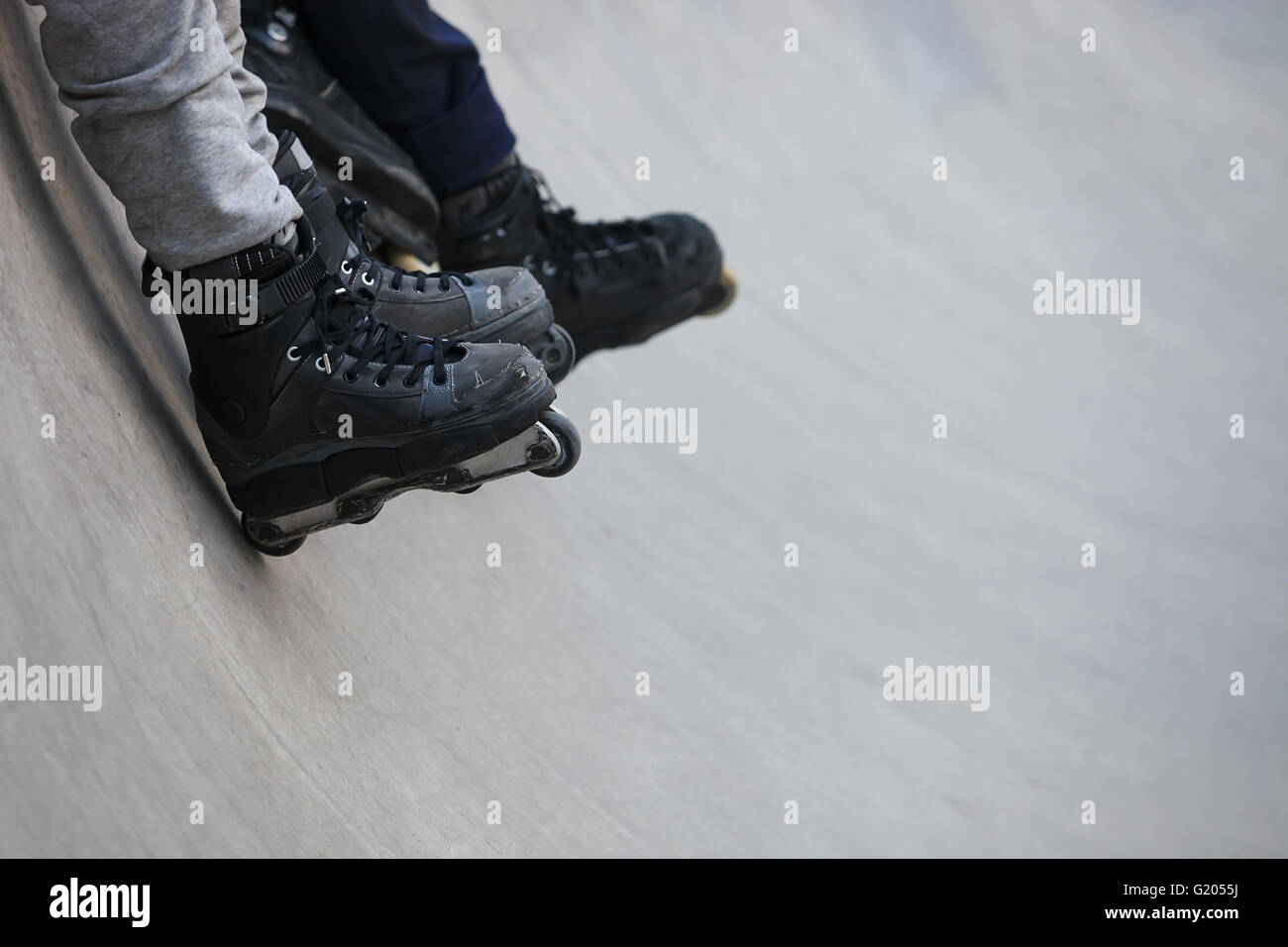 Feet of rollerblader wearing aggressive inline skates sitting on a