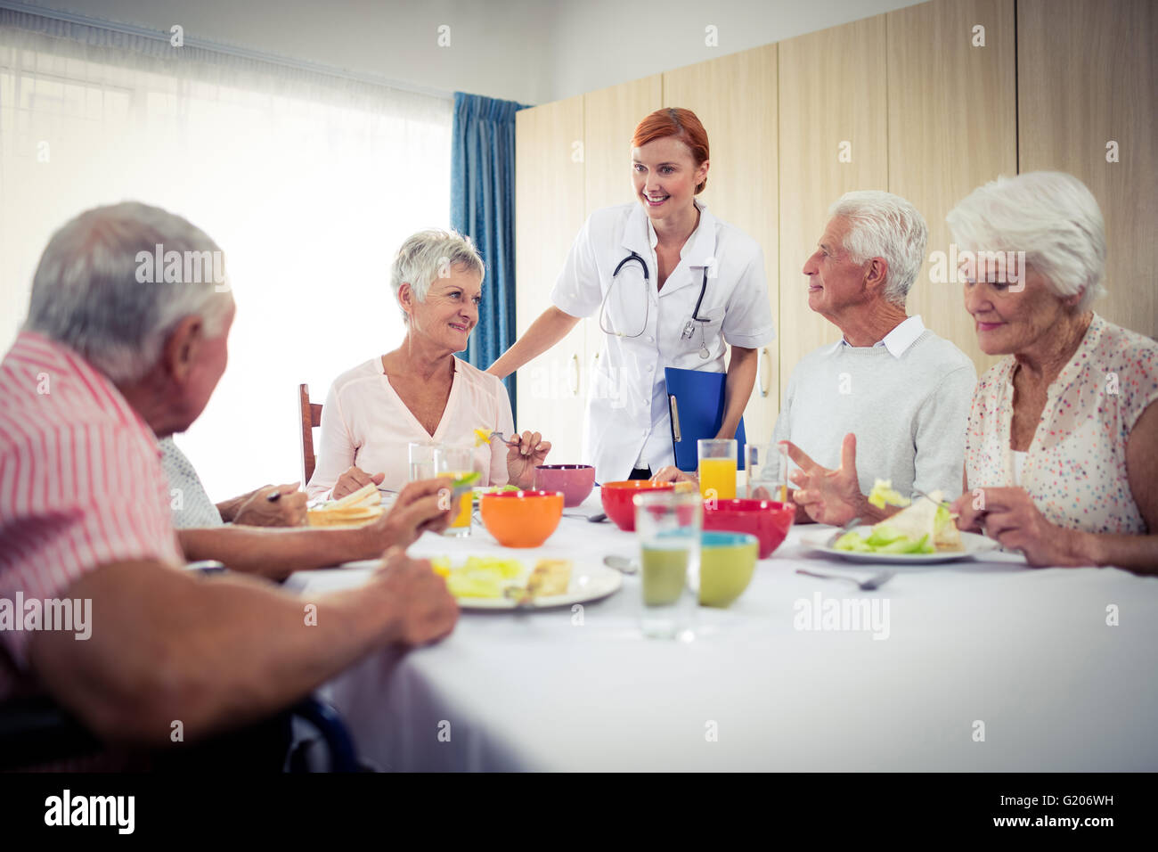 Pensioners at lunch with nurse Stock Photo
