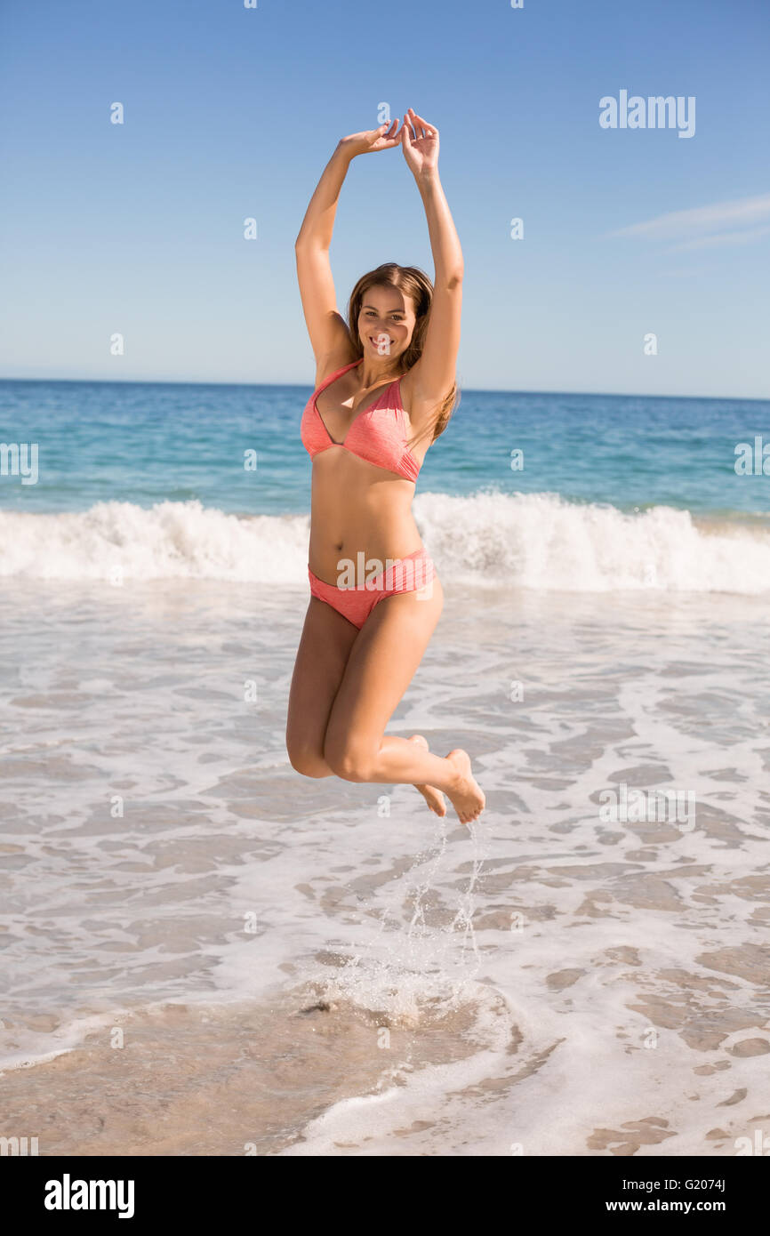 Young woman taking off swim suit cover with bikini underneath Stock Photo -  Alamy