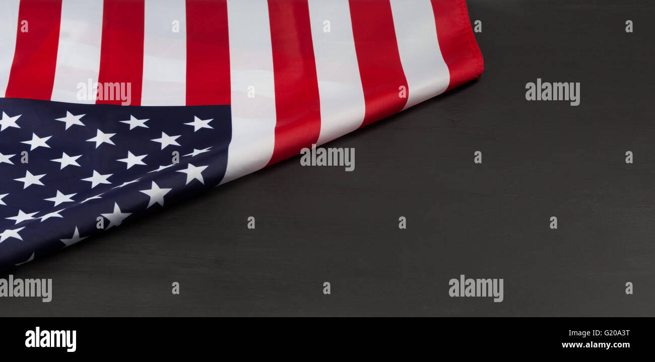 Folded American flag on black chalkboard with copy space Stock Photo