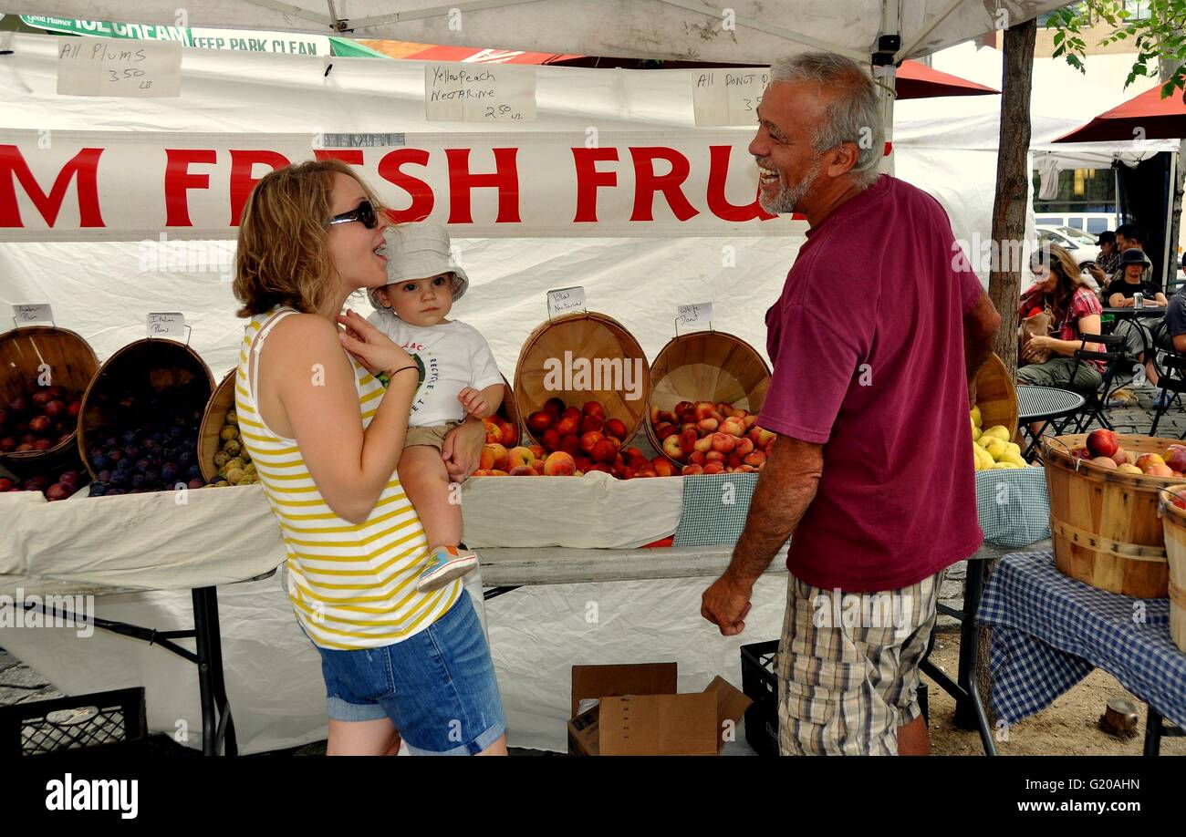 New York City - August 12, 2011: Woman with  her baby converses with one of the friendly farmers at the Lincoln Square Saturday Stock Photo