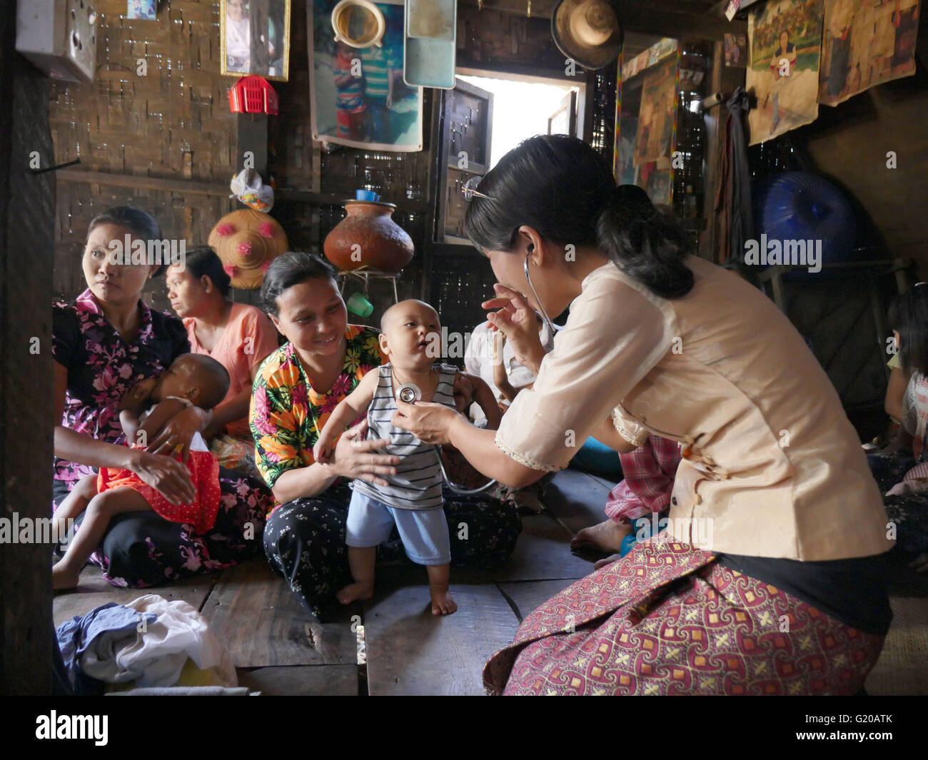 MYANMAR Hlaing Thayer, a slum of Yangon where people were relocated after the 2008 typhoon. MCHAN is active in this area with its community based health program. Visiting a house where MCHAN performs health check-ups and conducts workshops. MCHAN nurse Monica Yaw Myu Hli examines a healthy baby. Stock Photo