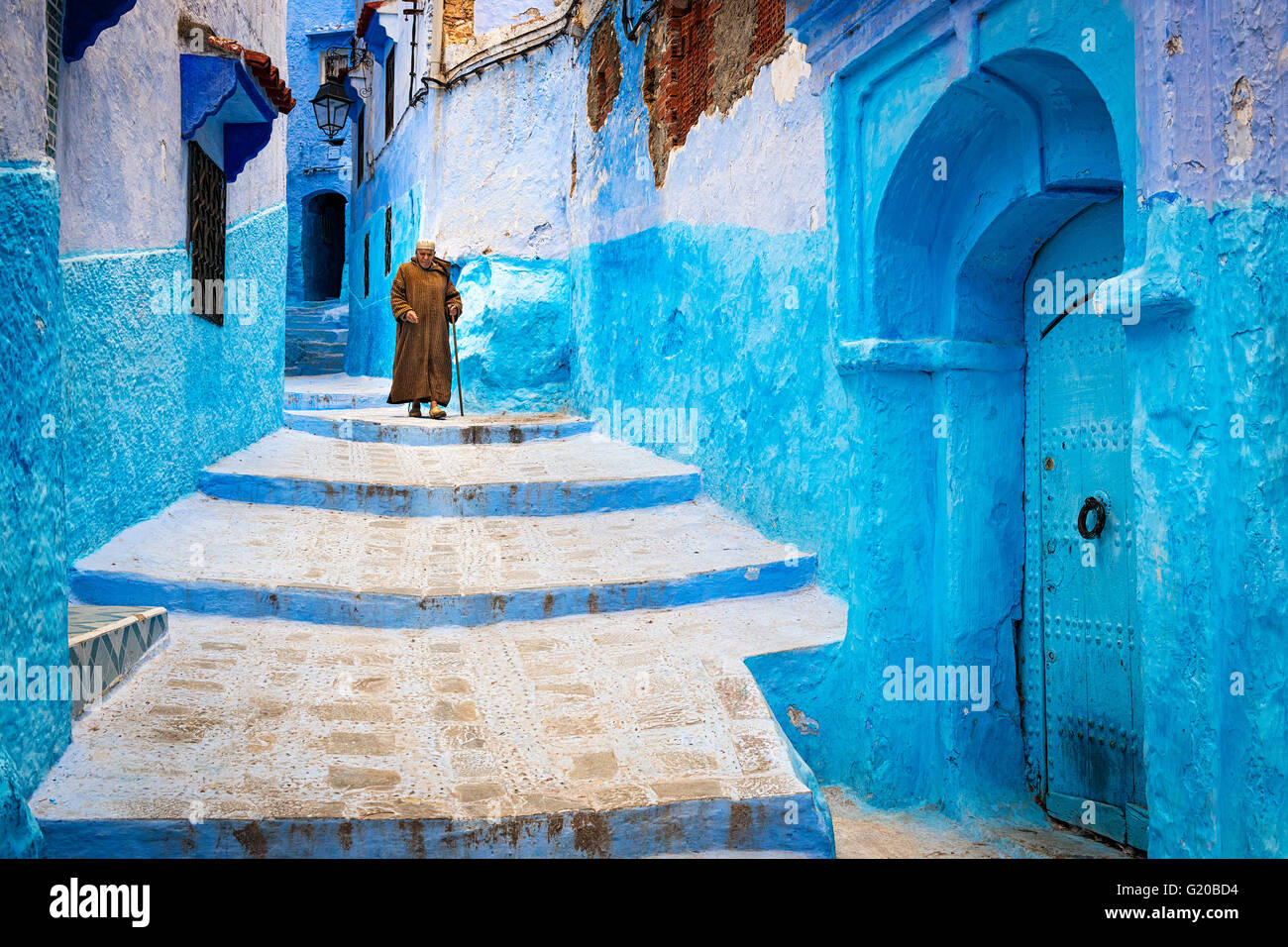 Chefchaouen, Morocco - April 10, 2016: An old man walking in a street of the town of Chefchaouen in Morocco. Stock Photo