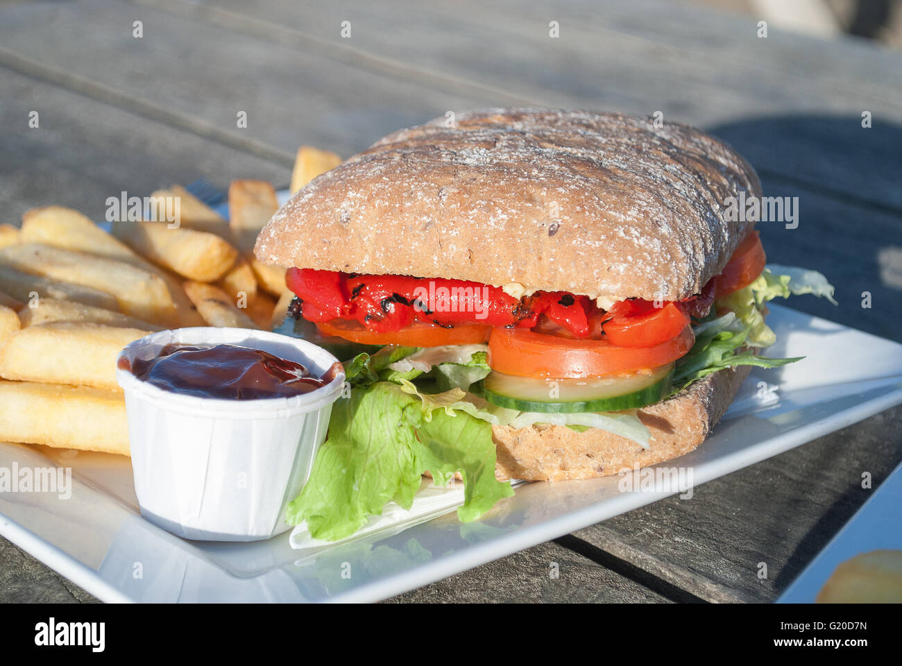 Vegan Roasted Pepper and Mixed Salad Sandwich, with chips and tomato sauce. Stock Photo