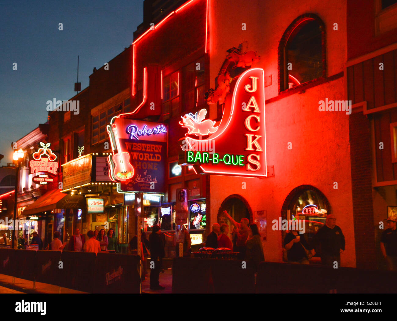 Neon signs for the honky tonks, restaurants and gift stores lure tourists at night on Broadway in Nashville, TN, Music City USA Stock Photo