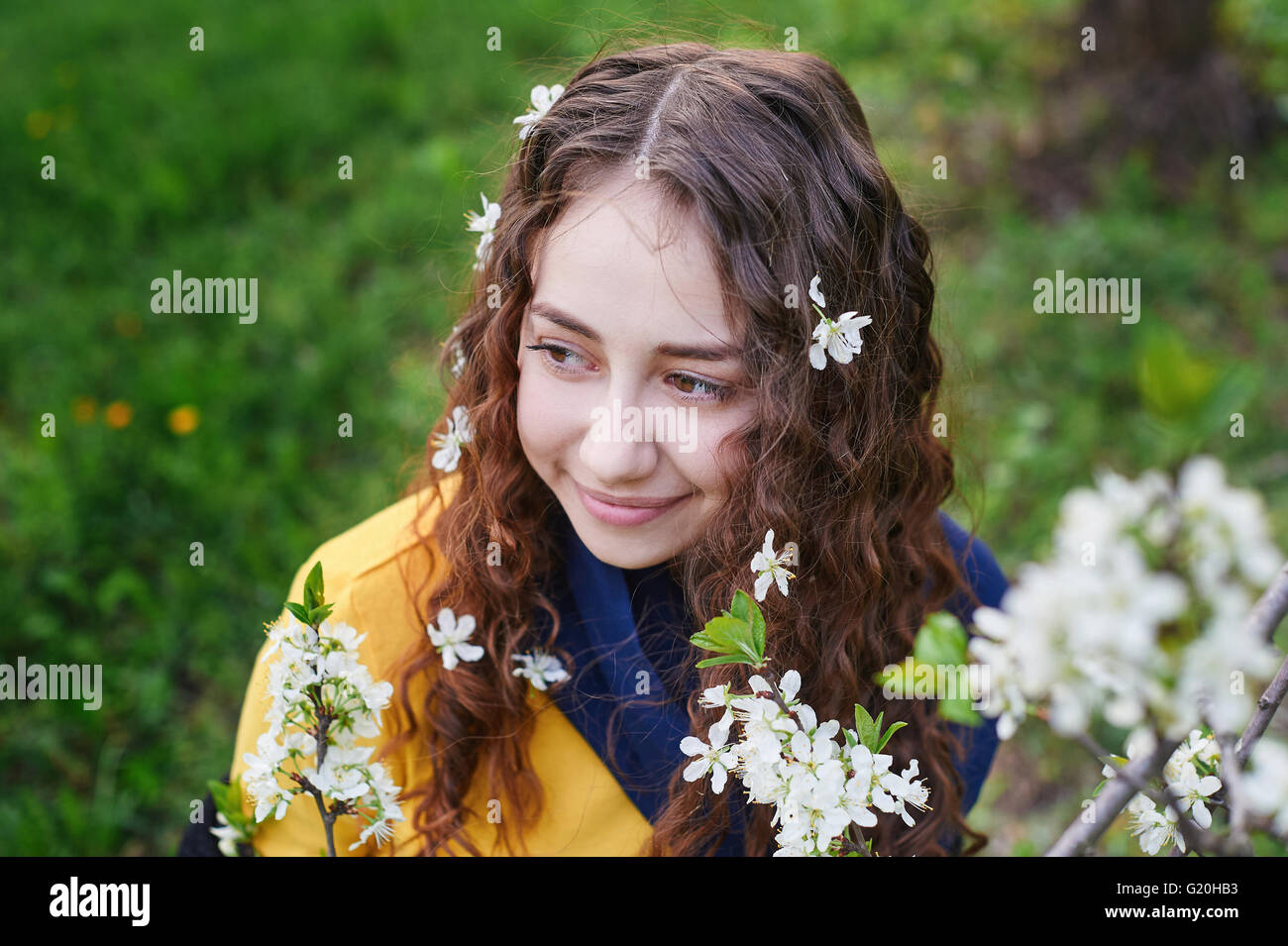 close up of beautiful young woman walking in a blossoming spring garden Stock Photo