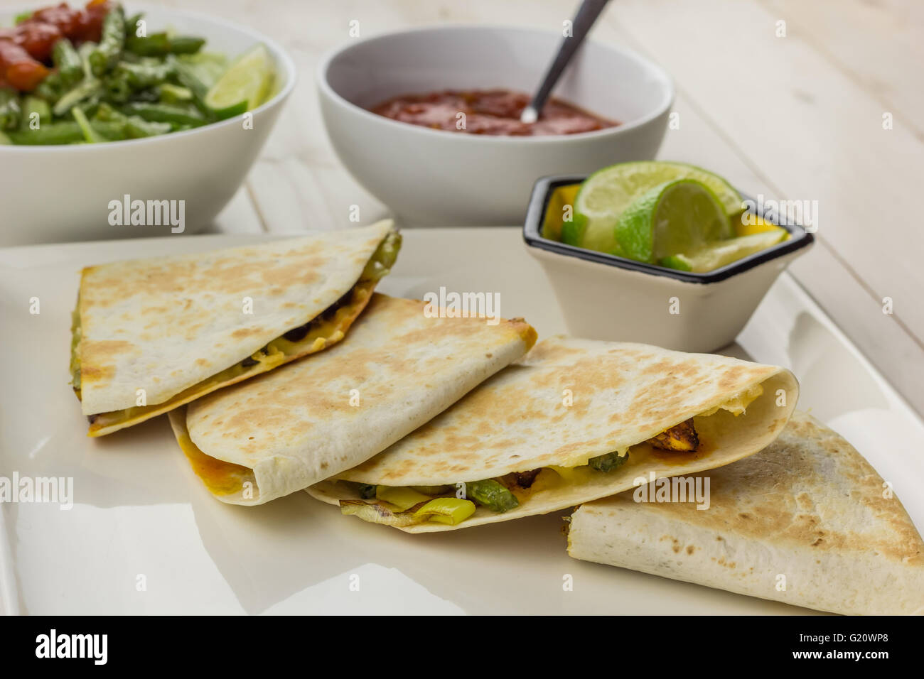 Mexican quesadillas with chicken, green beans salad and salsa on a white plate Stock Photo