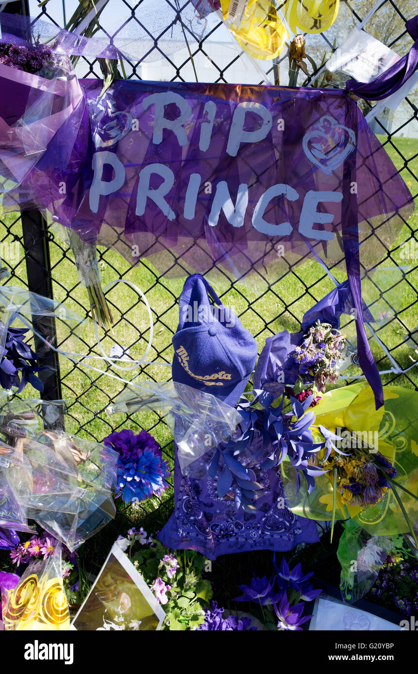 Large 'RIP Prince' printed on purple fabric on fence with purple balloons and flowers. Paisley Park Chanhassen Minnesota MN USA Stock Photo