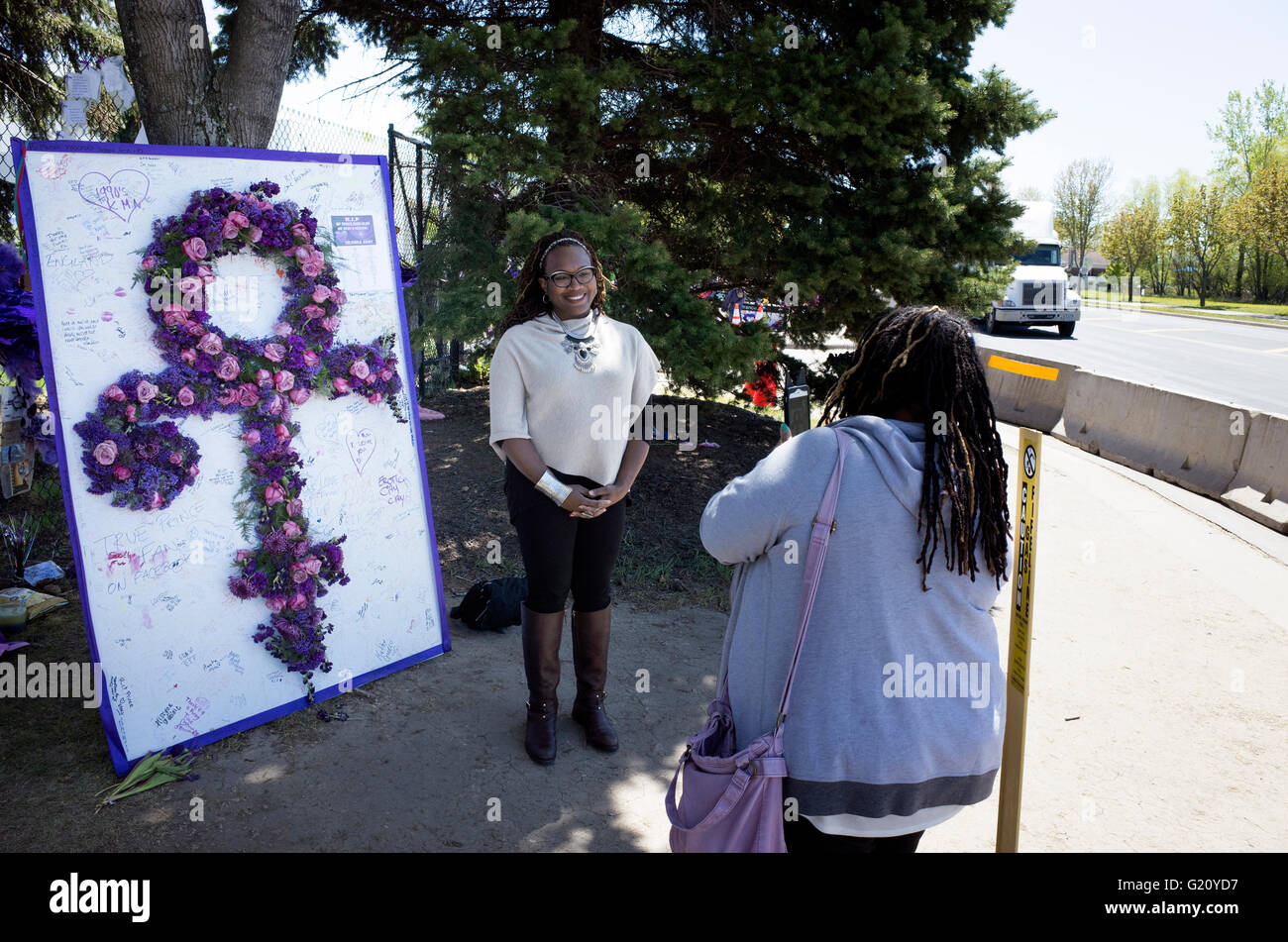 Black woman posing by Prince life-size purple floral 'Love Symbol'. Paisley Park Studios Chanhassen Minnesota MN USA Stock Photo