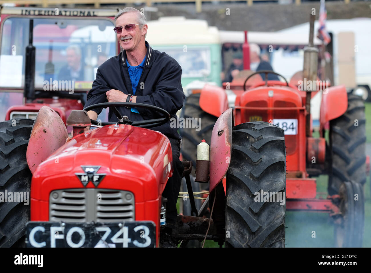 Royal Welsh Spring Festival, Sunday 22nd May 2016 - A farmer enjoys a laugh as the old tractors start their engines waiting for start of the classic vehicle and vintage tractor parade in the main display arena on the second day of the Royal Welsh Spring Festival. Stock Photo