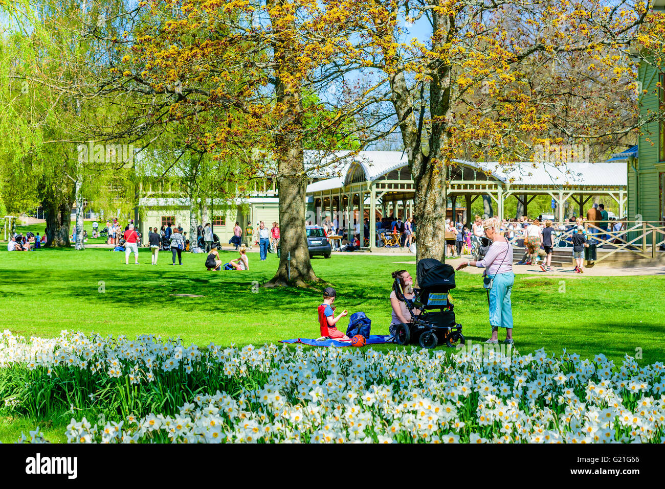 Ronneby, Sweden - May 8, 2016: People enjoying the fine weather while relaxing in the park. Ongoing flea market in the open buil Stock Photo