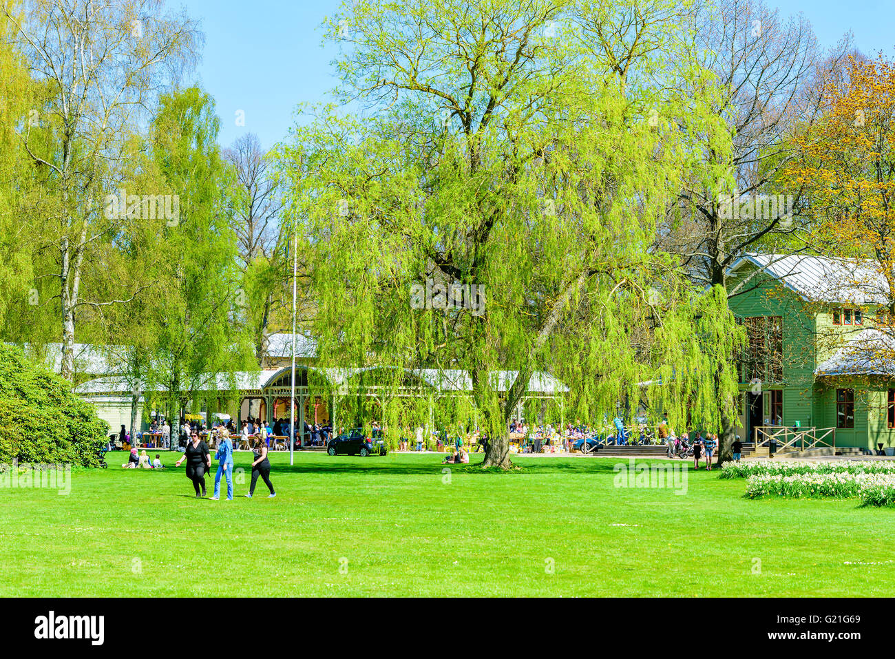 Ronneby, Sweden - May 8, 2016: People enjoying the fine weather while relaxing in the park. Ongoing flea market in the open buil Stock Photo