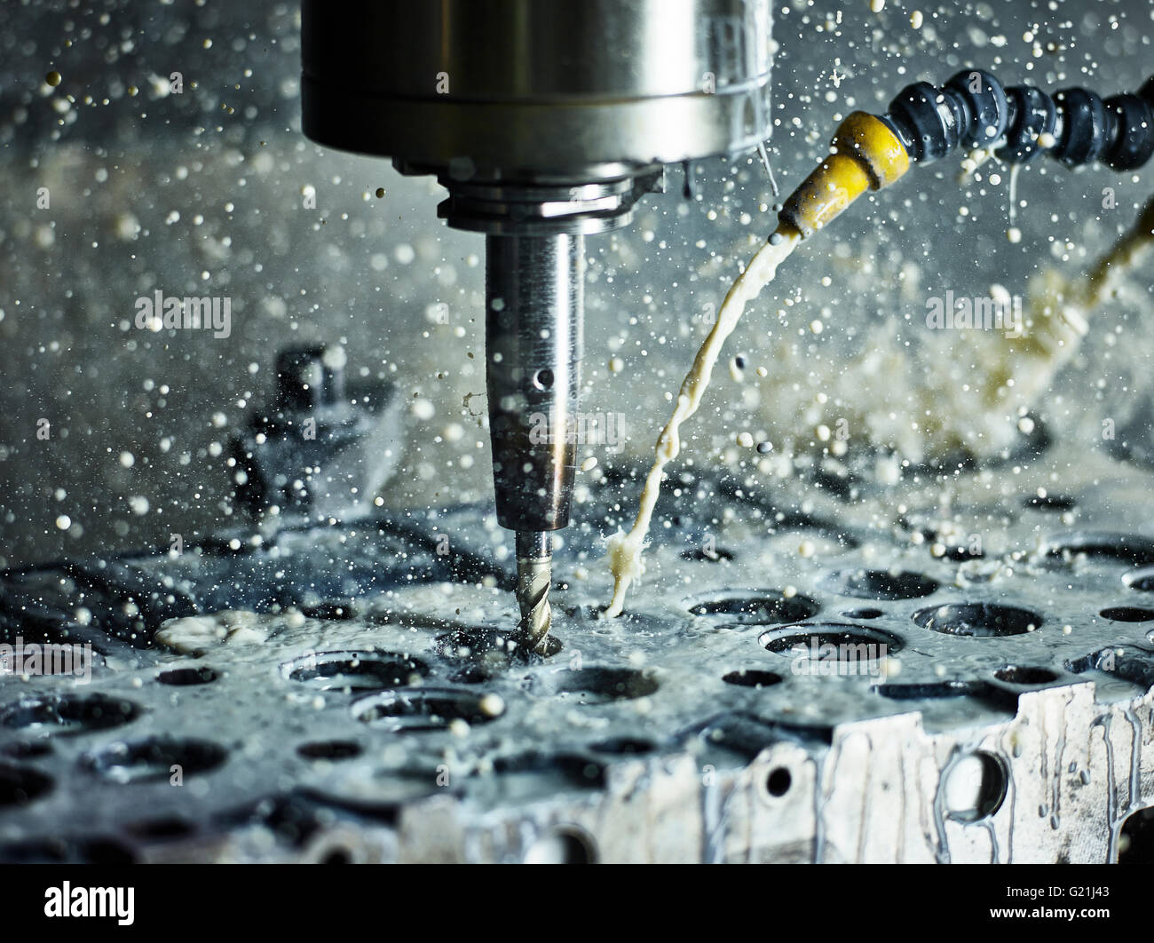CNC machine, CNS milling machine drilling the valve opening in a cylinder head, cooled by liquid, Austria, Europe Stock Photo