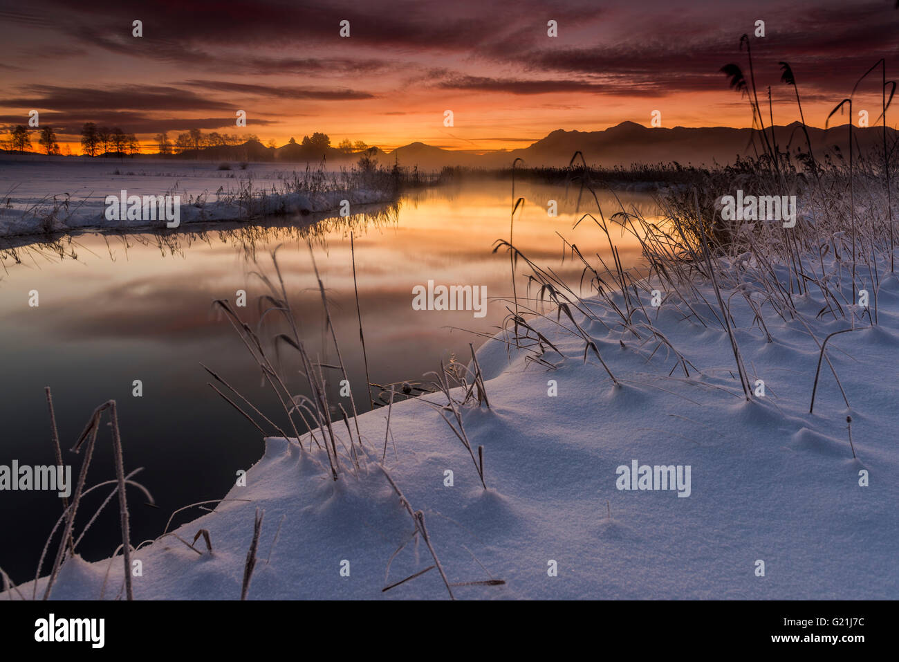 Sunrise over river in winter landscape, Murnau, Upper Bavaria, Germany Stock Photo