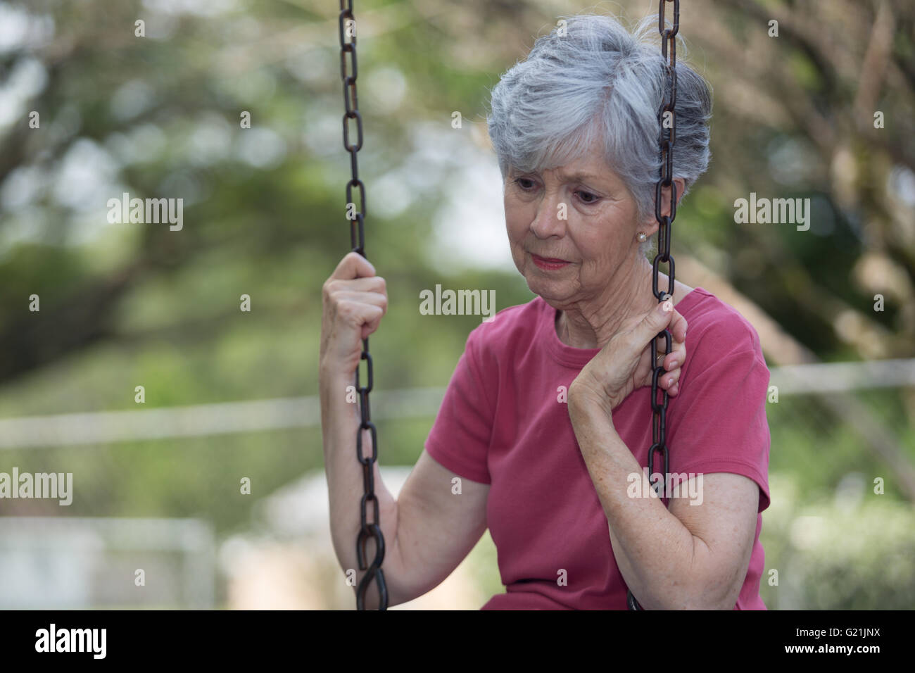 Women looking pensive on a swing Stock Photo