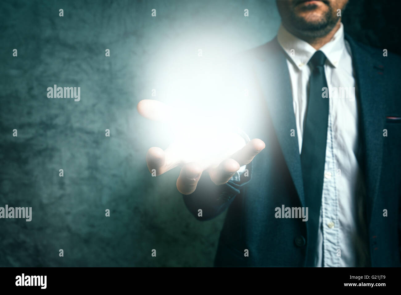 Business vision concept with elegant adult businessman holding bright light of new ideas in hand Stock Photo
