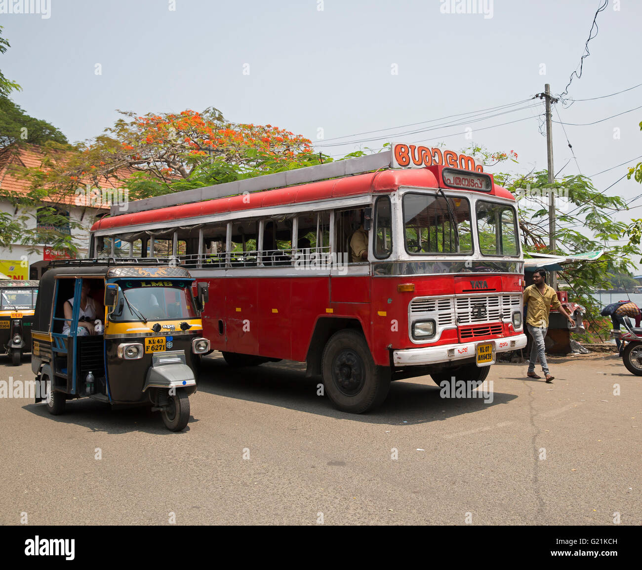 Tut Tut next to an old red bus in Cochin India Stock Photo