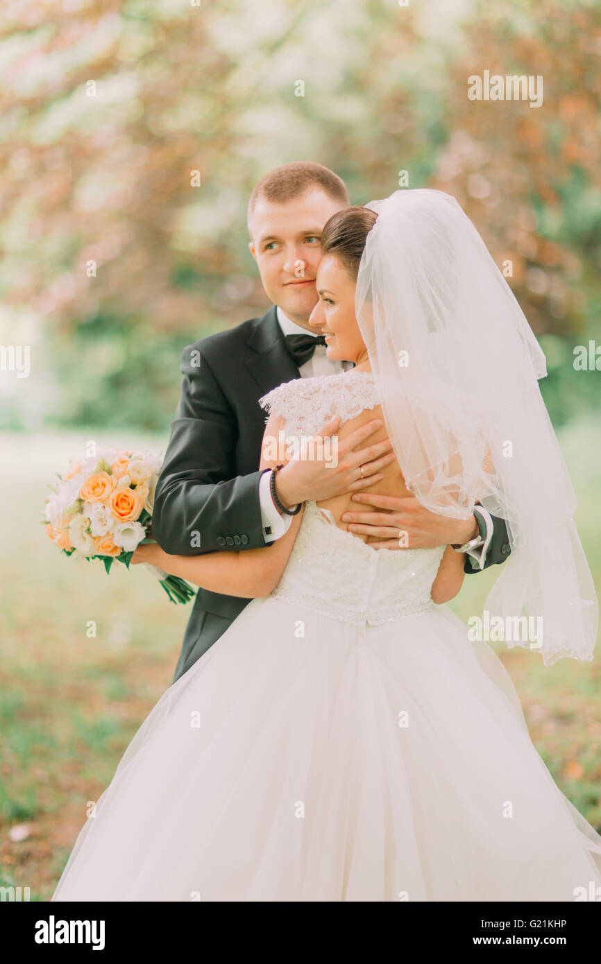 Happy wedding couple, bride and groom embracing in the autumn forest ...
