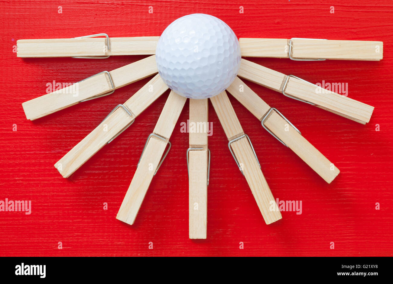 Set of cloth pegs and golf ball on wooden red table Stock Photo Alamy
