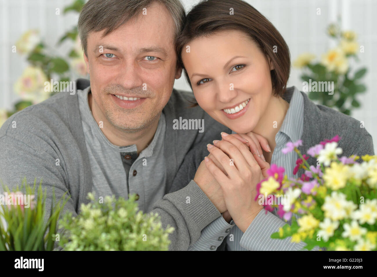 Beautiful smiling couple in flowers Stock Photo - Alamy