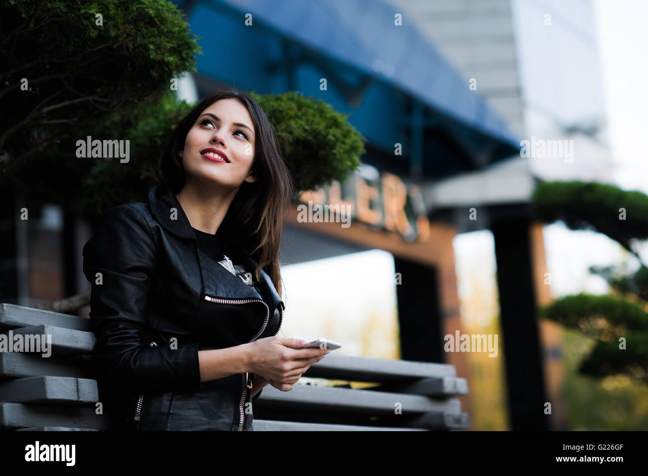 Smiling woman sending sms on the street Stock Photo