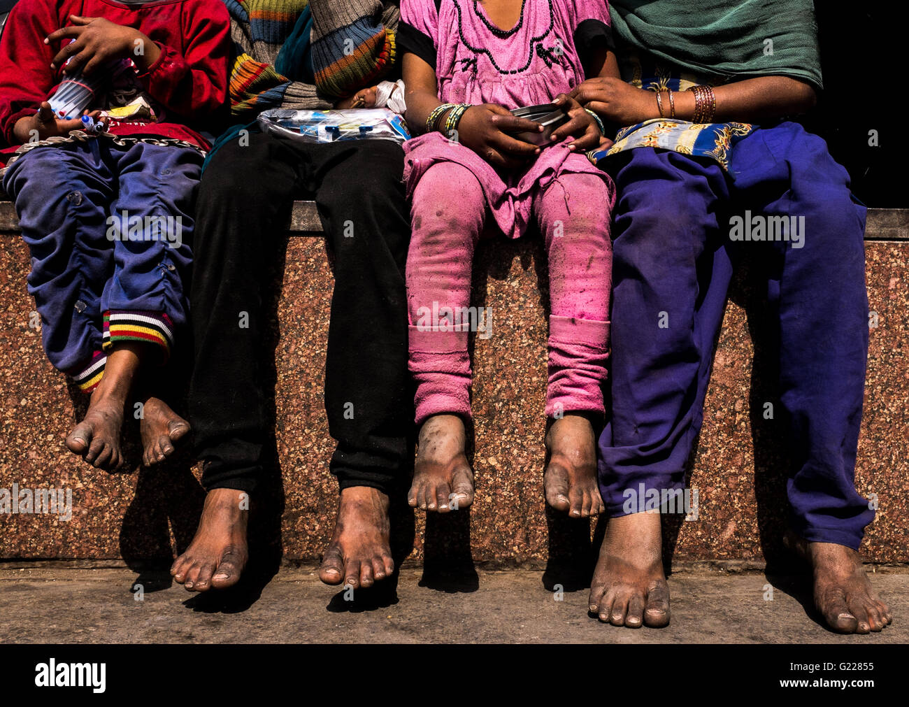 Homeless children sitting on a wall in Delhi, India, Stock Photo