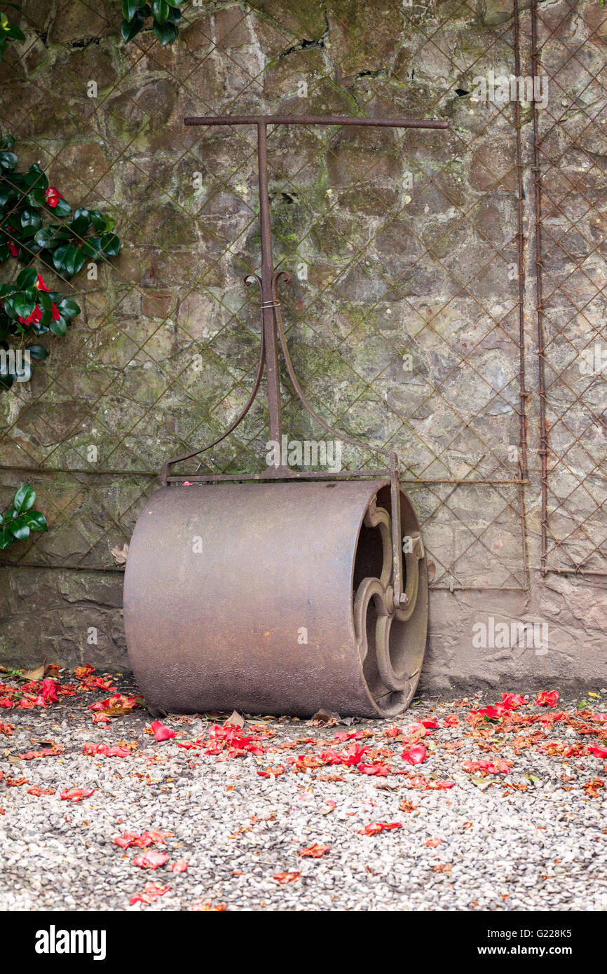 Close up of an old vintage garden roller leaning against a wall, UK Stock Photo