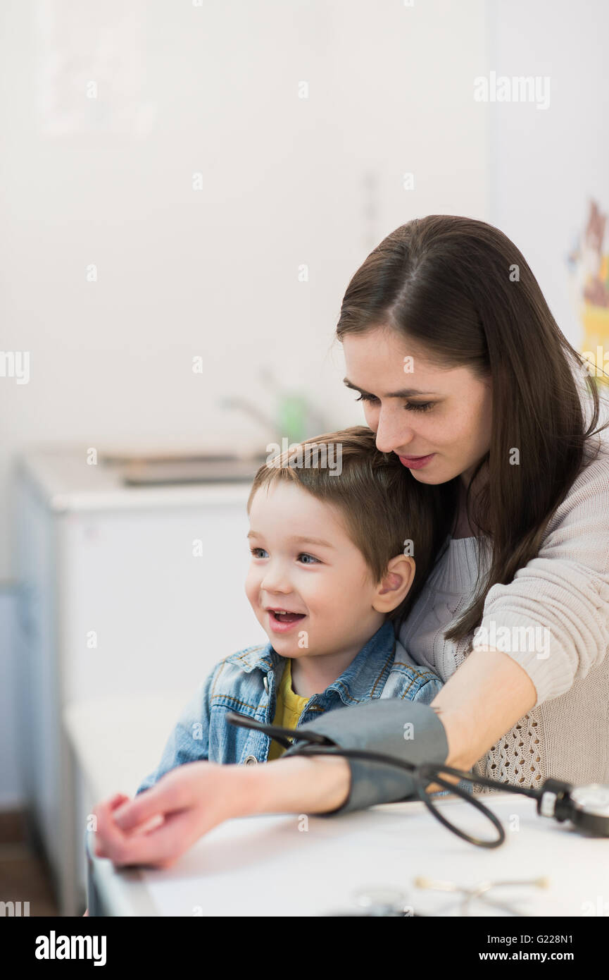 Attractive woman and her kid with a blood pressure meter tonometer Stock Photo